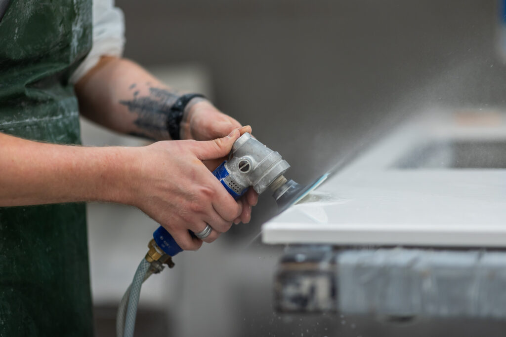 stone fabricator wet polishing a stone kitchen worktop
